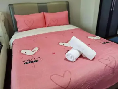 a bed with a pink bedspread with hearts on it at WOW Strait Quay Luxury Suite Room in Tanjong Tokong