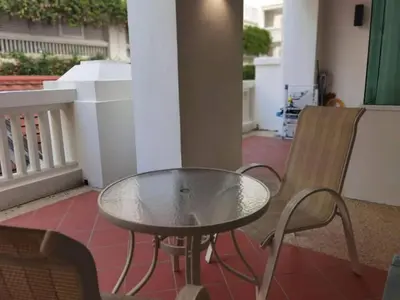 a glass table and a chair on a patio at WOW Strait Quay Luxury Suite Room in Tanjong Tokong