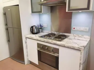 a kitchen with a stove and a refrigerator at WOW Strait Quay Luxury Suite Room in Tanjong Tokong