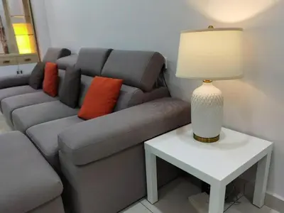 a living room with a couch and a table with a lamp at SUMMERSET 8PAX 3BR LUXURY SEAVIEW SUITE ROOM in George Town