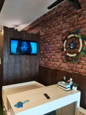 a living room with a brick wall and a tv at Sekinchan PaddyCruise Homestay Wifi in Sekincan