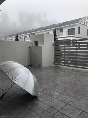 a white umbrella laying on a patio in front of a house at New 2 storey-Majestic Homestay 3 min to Night Market in Brinchang