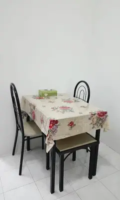 a dining room table with a floral table cloth on it at Yussal Homestay in Simpang Ampat Semanggol