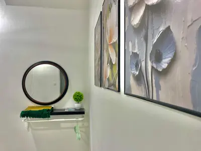 a bathroom with a mirror and some pictures on the wall at Hanan Homestay Klebang Ipoh with a view of Mount Korbu, for Musl!m only!! in Ipoh