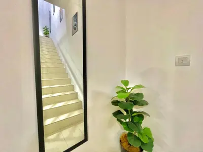 a mirror with a plant next to a staircase at Hanan Homestay Klebang Ipoh with a view of Mount Korbu, for Musl!m only!! in Ipoh