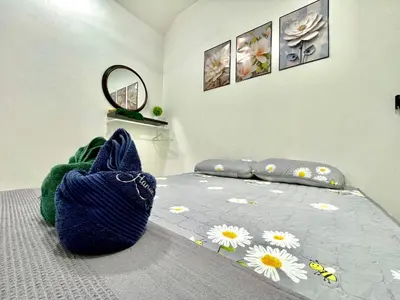 a bedroom with a bed with a blue bag on it at Hanan Homestay Klebang Ipoh with a view of Mount Korbu, for Musl!m only!! in Ipoh