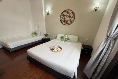 a room with two beds and a plate of flowers on it at Carnarvon Heritage Lodge in George Town