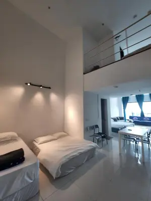 a white room with two beds and a table at Sunrise Gurney Premium Suite - Gurney Drive in George Town