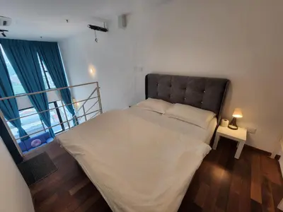 a bedroom with a bed and a lamp on a table at Sunrise Gurney Premium Suite - Gurney Drive in George Town