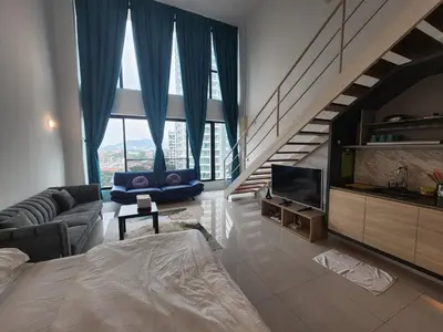 a living room with a couch and a tv at Sunrise Gurney Premium Suite - Gurney Drive in George Town