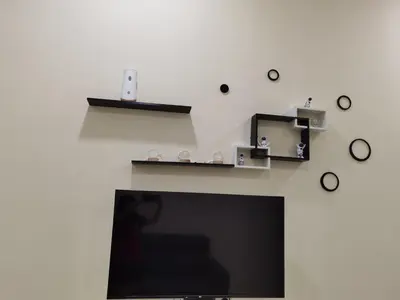 a living room with a tv and clocks on the wall at My Homestay Sitiawan - Astronaut Space House 8 Pax in Sitiawan