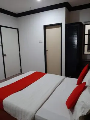 a bedroom with a large bed with red pillows at G CITY HOTEL in Teluk Intan