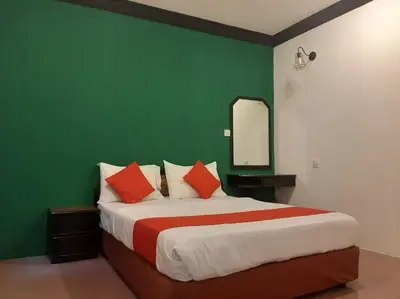 a bedroom with a large bed with a green wall at G CITY HOTEL in Teluk Intan