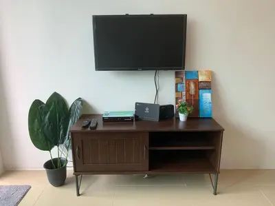 a wooden desk with a television on a wall at New GoldenHill Condo 3BR 1Min Pasar Mlm Cameron Highlands in Tanah Rata