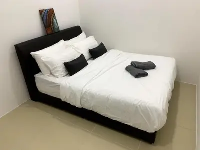 a bed with black and white sheets and pillows at New GoldenHill Condo 3BR 1Min Pasar Mlm Cameron Highlands in Tanah Rata