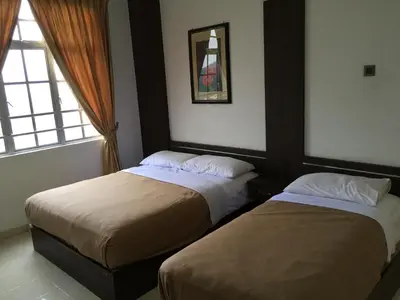 two beds in a hotel room with a window at Cameron Pasar Malam Apartment @ Crown Imperial Court in Cameron Highlands