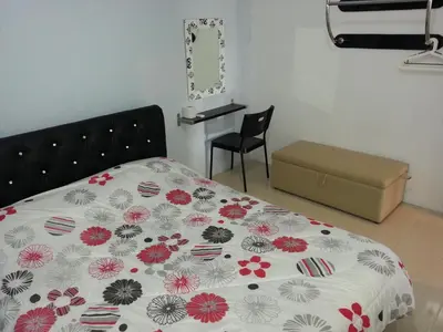 a bedroom with a bed with a floral comforter at Cameron Pasar Malam Apartment @ Crown Imperial Court in Cameron Highlands