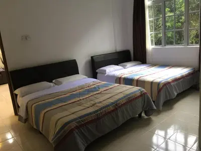 a bedroom with two beds and a window at Cameron Pasar Malam Apartment @ Crown Imperial Court in Cameron Highlands