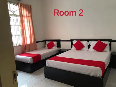 two beds in a room with red and white sheets at 66 Semi-D Homestay in Teluk Intan