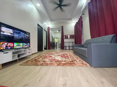 a living room with a couch and a flat screen tv at Ainaz Homestay Balik Pulau in Balik Pulau