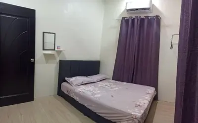 a small bedroom with a bed and purple curtains at Ainaz Homestay Balik Pulau in Balik Pulau