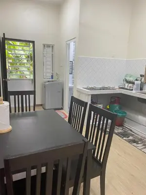 a kitchen with a table and chairs in a room at Ainaz Homestay Balik Pulau in Balik Pulau