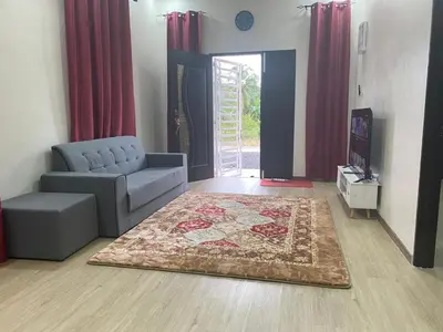 a living room with a couch and a rug at Ainaz Homestay Balik Pulau in Balik Pulau