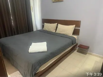 a bed with a blue comforter and two pillows at Pangkor L30 88 Corner villa House in Pangkor