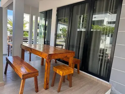 a wooden table and a bench on a porch at Pangkor L30 88 Corner villa House in Pangkor