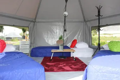 a tent with two beds and a table in it at Fraser Valley Kuala Kubu Bharu in Kuala Kubu Baharu