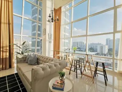 a living room with a couch and a large window at Maritime Suites Penang in Jelutong