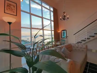 a living room with a couch and a large window at Maritime Suites Penang in Jelutong