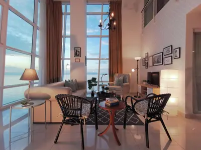 a living room with two chairs and a couch at Maritime Suites Penang in Jelutong
