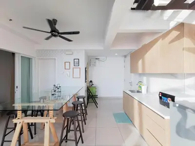a kitchen with a ceiling fan and a counter with stools at Maritime Suites Penang in Jelutong