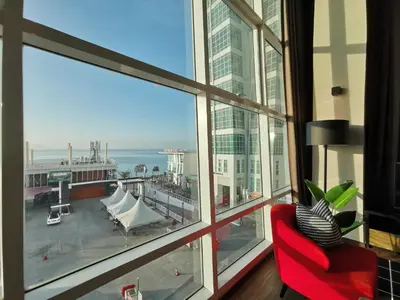 a room with a red chair and a large window at Maritime Suites Penang in Jelutong