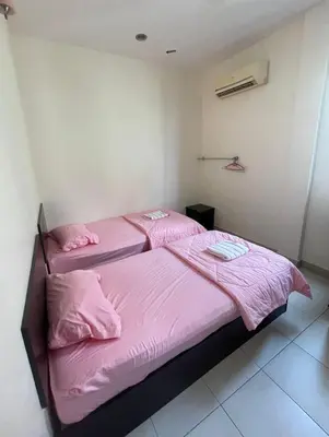 a bedroom with a pink bed with pink sheets at Intanova Hotel in Teluk Intan