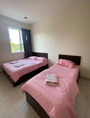 two beds in a room with pink sheets and a window at Intanova Hotel in Teluk Intan