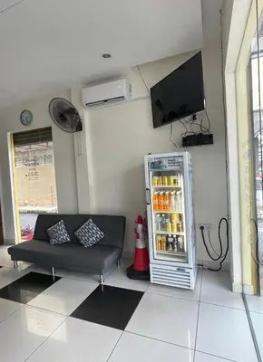 a living room with a refrigerator and a couch at Intanova Hotel in Teluk Intan