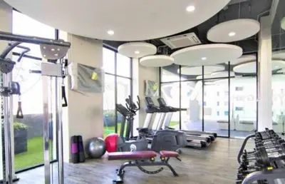 a gym with treadmills and ellipticals in a room with windows at Jazz Service Suites 2 bedroom 35-1 by Yen's Sojourn in Bagan Jermal