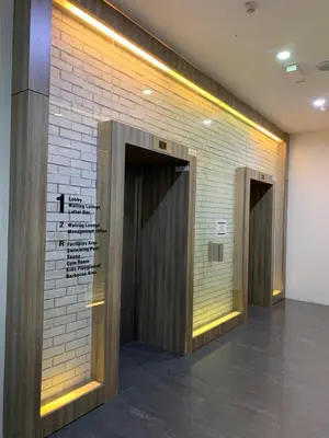 a row of elevators in a room with a brick wall at Jazz Service Suites 2 Bedroom 23-3 by Yen's Sojourn in Bagan Jermal