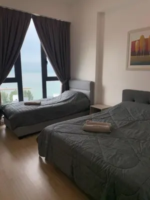 a bedroom with two beds and a large window at Jazz Service Suites 2 Bedroom 23-3 by Yen's Sojourn in Bagan Jermal