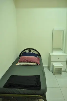 a bed in a room with a mirror and a bed sidx sidx sidx at De’ Nuhir Homestay Teluk Senangin in Kampong Batu Tiga