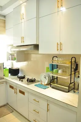 a kitchen with white cabinets and a counter top at De’ Nuhir Homestay Teluk Senangin in Kampong Batu Tiga