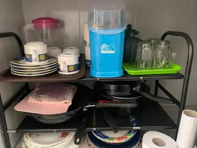 a shelf in a kitchen with dishes and a blender at Damai Homestay in Kampong Jabi