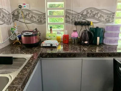 a kitchen with a counter top with appliances on it at Damai Homestay in Kampong Jabi