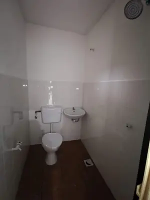 a white bathroom with a toilet and a sink at SB PRIMA VILLA APRTMENT in Tanah Rata