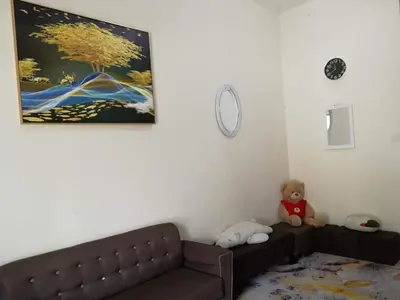 a brown couch in a living room with a teddy bear at Homestay Dorani Sungai Besar in Sungai Besar