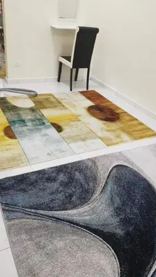 a table with a rug and a chair in a room at Homestay Dorani Sungai Besar in Sungai Besar