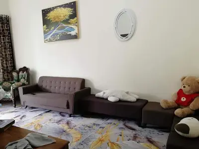 a living room with a couch and a teddy bear at Homestay Dorani Sungai Besar in Sungai Besar