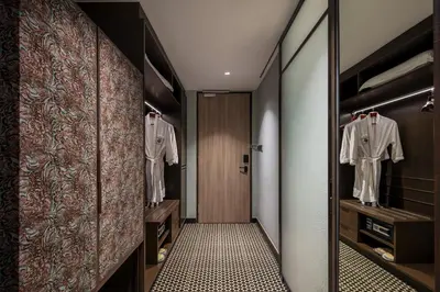 a walk in closet with white shirts on hangers at The George Penang by The Crest Collection in George Town